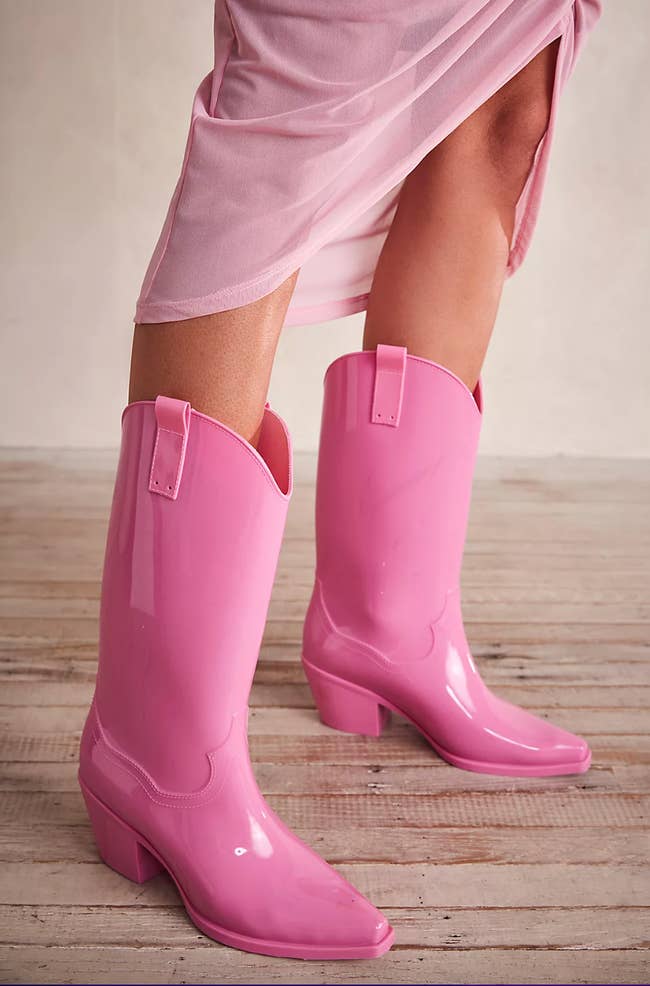 model wearing bright pink cowboy rainboots