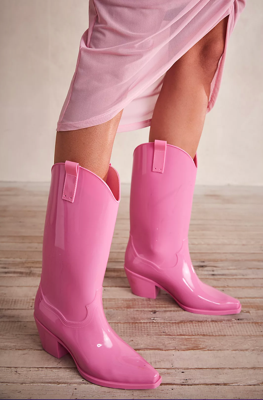 model wearing bright pink cowboy rainboots