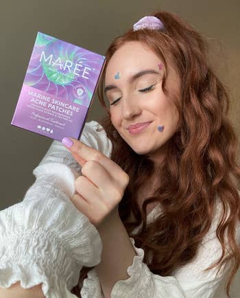 reviewer holds container  portion    wearing pimple patches