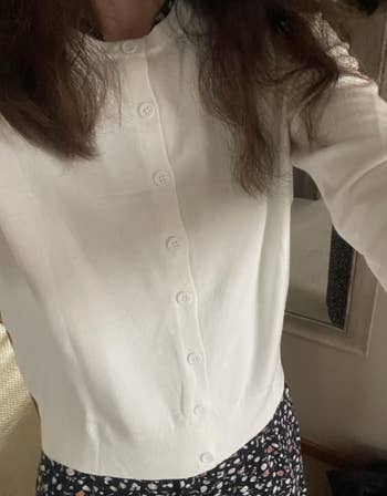 Person wearing a button-up sweater implicit    a patterned dress