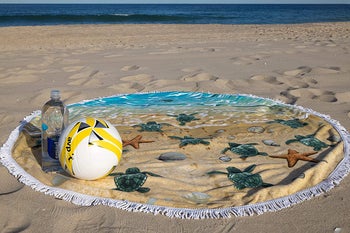 Image of the round turtle towel in the sand