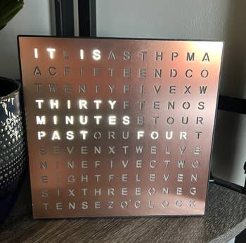 A word clock displaying a lit phrase to indicate the current time, suitable for home decor