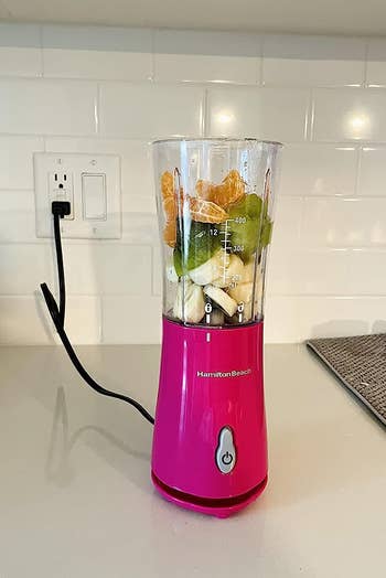 a reviewer's pink blender with fruit un blended