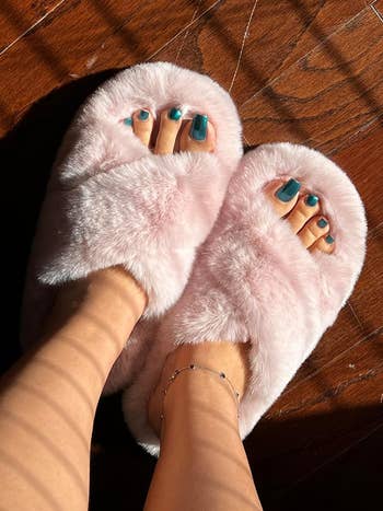 reviewer in pink criss-cross fuzzy slippers