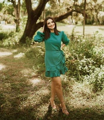 reviewer wearing the dress in green, posing outside