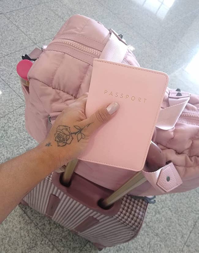 a reviewer holding a pink passport book