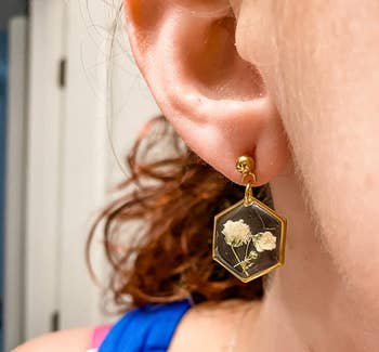 side view of a reviewer wearing the pressed flower earrings