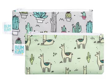 Two of the snack bags: one in gray with images of plants and one in green with images of llamas