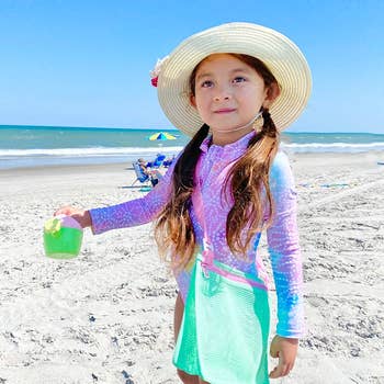 travel A child with a green mesh bag strapped across their torso 