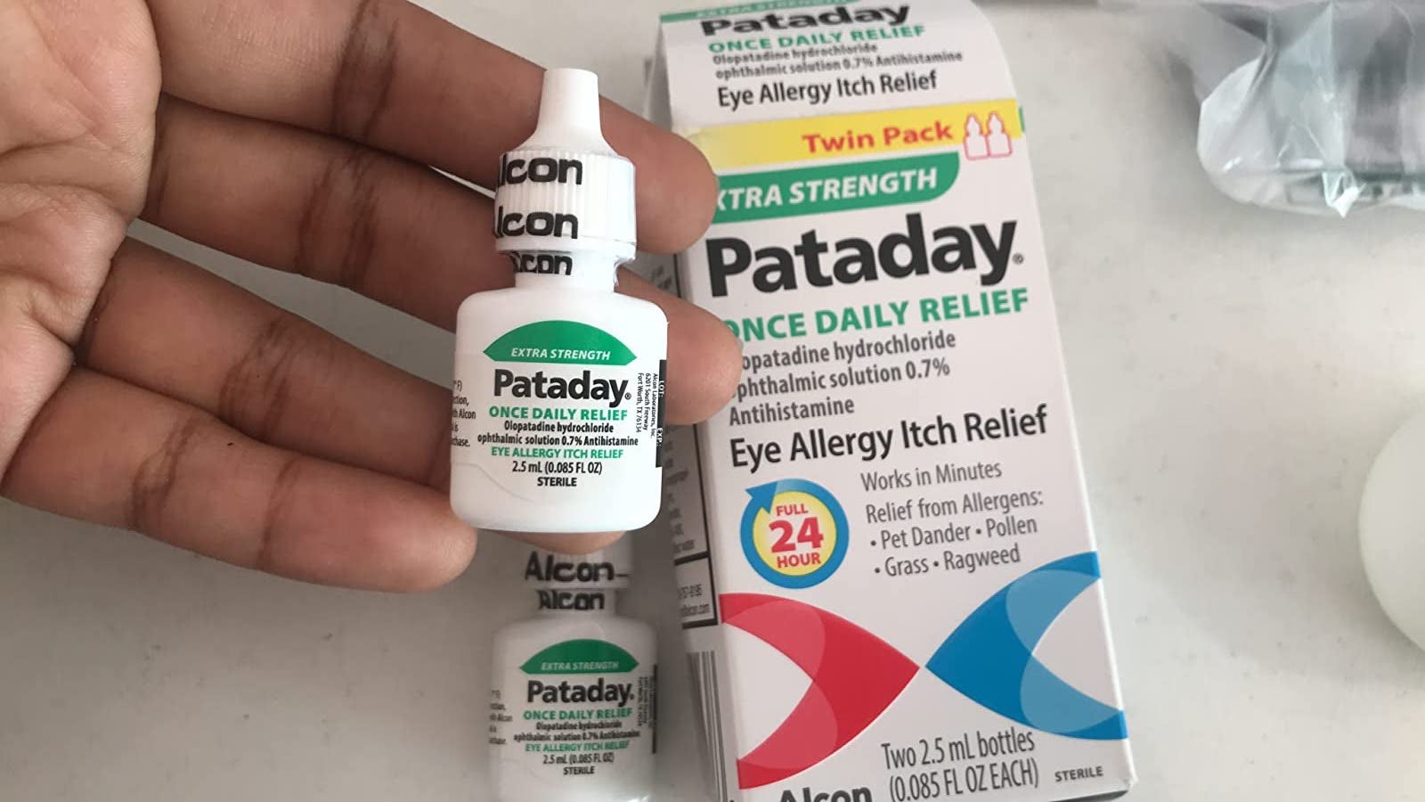 a small bottle of pataday once daily relief in a reviewer's hand