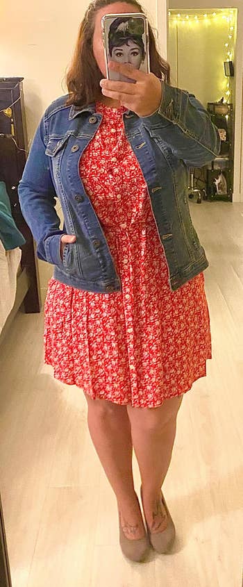 Reviewer wearing the blue jean jacket with a red dress