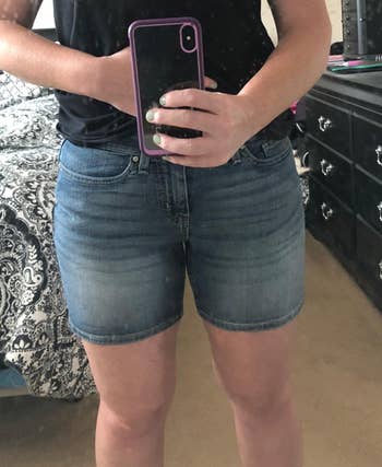 Reviewer wearing blue denim shorts in mirror 