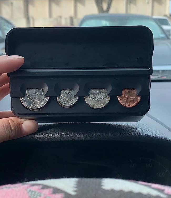 Reviewer holding coin holder with quarters, dimes, nickels, and pennies