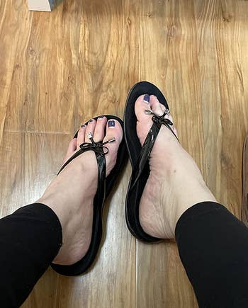 reviewer wearing the sandals in black