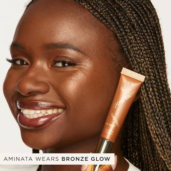 Smiling pistillate   holds a conduit  of Tarte Glow Tape with the statement   