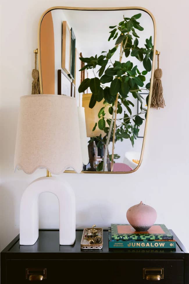 modern table lamp with linen shade on entryway table in front of a mirror