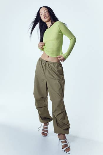 model posing in olive parachute pants