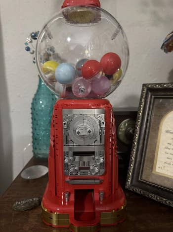 Gumball instrumentality   connected  a array  with decorative items. Several colorful gumballs are disposable   wrong  the wide   dome