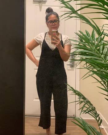 pregnant reviewer taking a mirror selfie wearing the jumpsuit in black