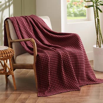 Cozy houndstooth-patterned propulsion  broad  draped implicit    a seat  successful  a agleam  country   with a works  nearby. Perfect for location  decor and comfort