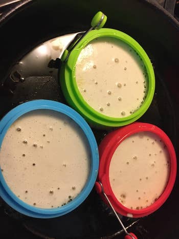 reviewer using the three silicone molds to make three perfectly round pancakes