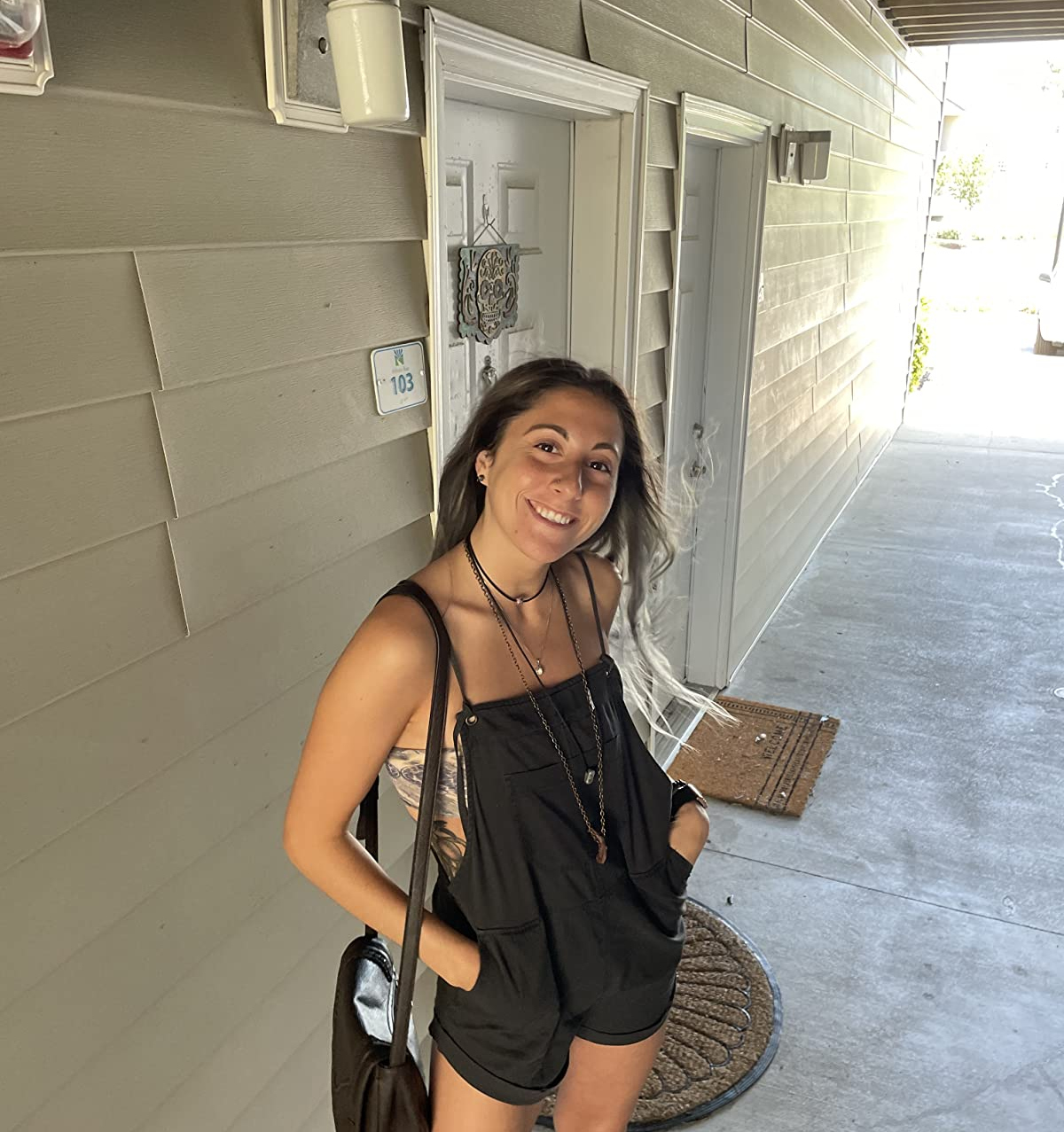 Reviewer is wearing a black slouchy overall and bandeau underneath