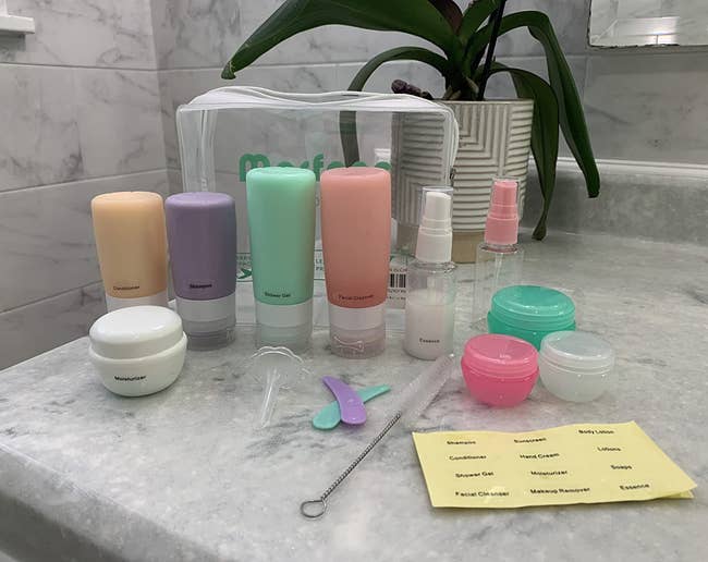 reviewer photo of the silicone bottles, spray bottles, jars, and travel bag