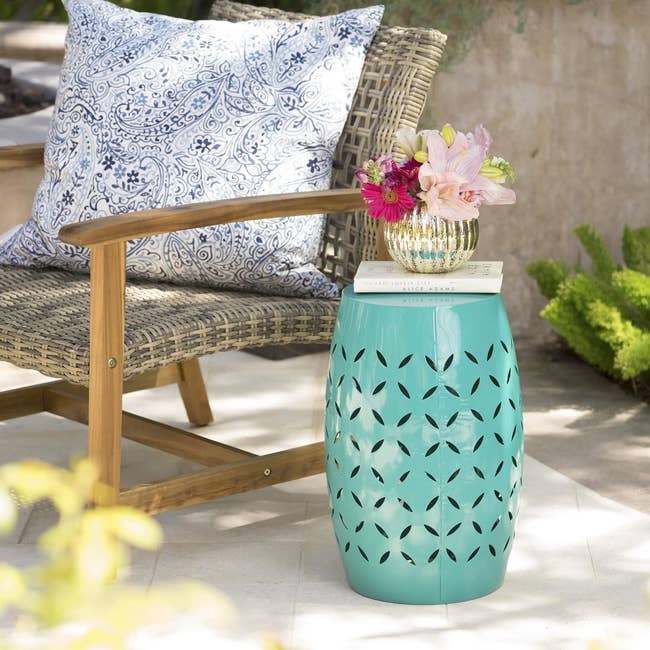 a teal side table outside next to a patio chair