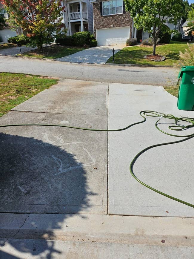 Driveway half dirty with mold and mildew buildup, half sparkling clean from pressure washing