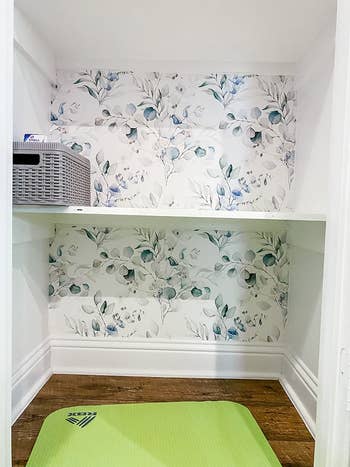 reviewer photo of the soft bluish floral wallpaper inside of a cabinet