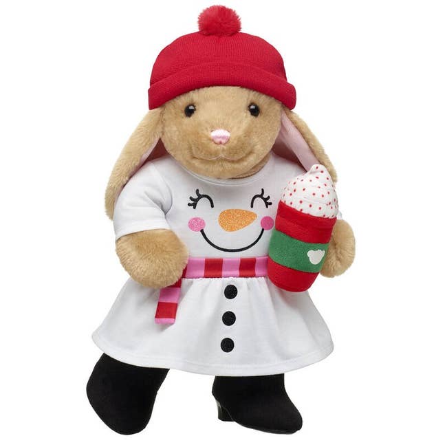 a plush rabbit with a winter beanie, snow man dress, boots, and a plush latte
