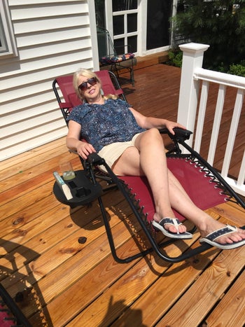 A reviewer in the dark red chair with the back reclined