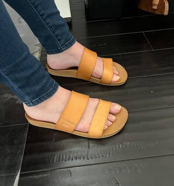 reviewer wearing tan slide sandals with wide straps, suitable for a casual shopping look