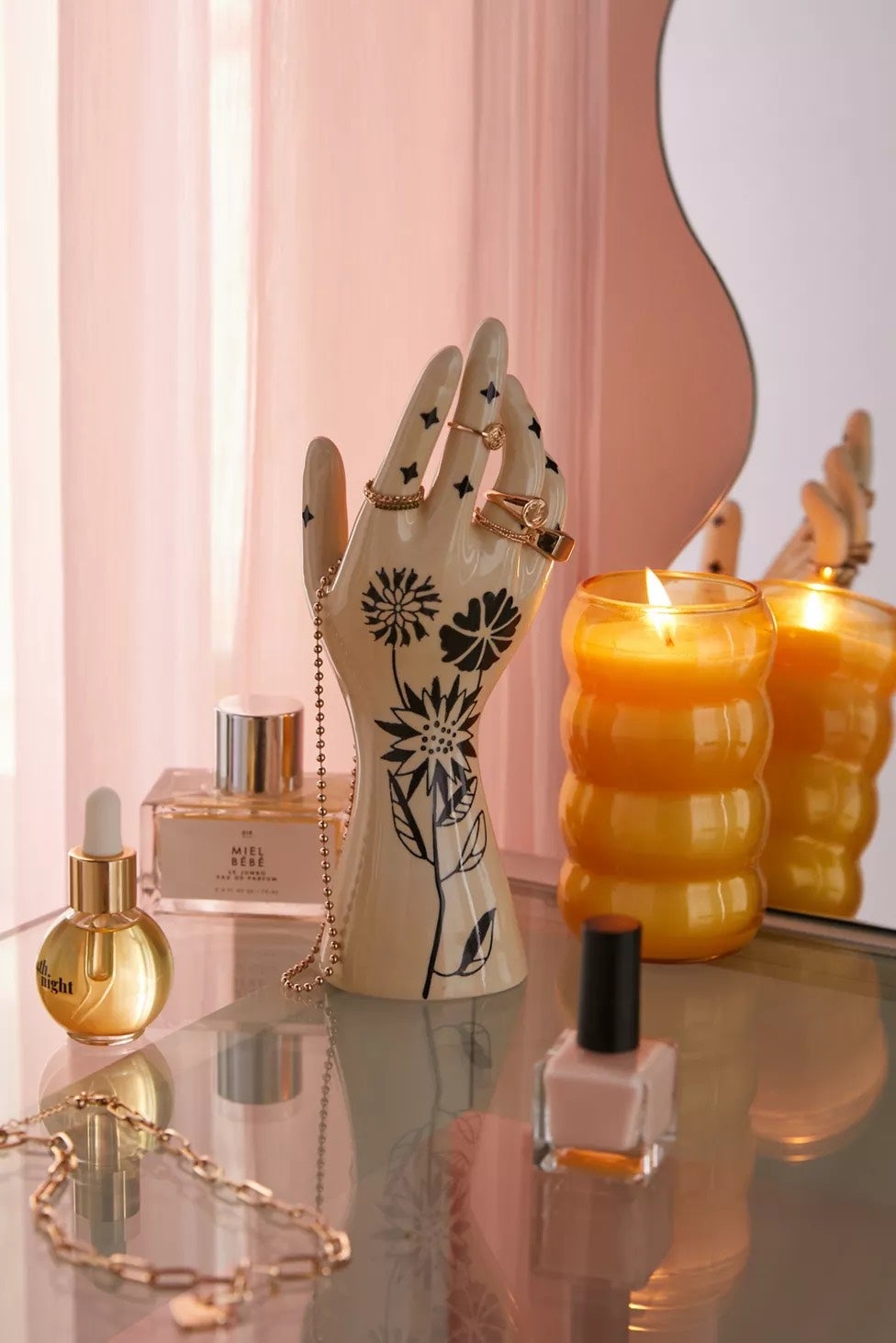 White ceramic hand with flowers painted on it that holds jewelry