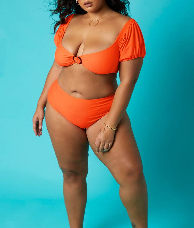 model posing in the orange two-piece