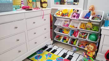 reviewer's photo showing their toys stored in the white and gray organizer