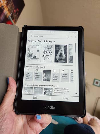 reviewer photo of them holding a black Kindle Paperwhite