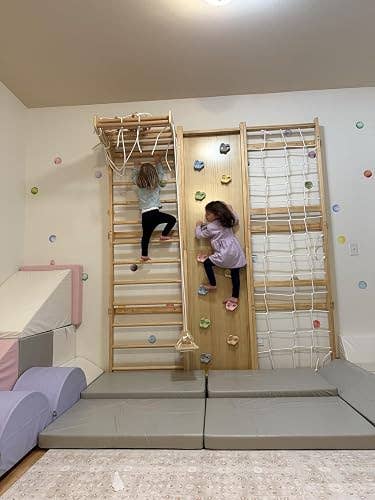 Two children ascent an indoor play gym with a woody climbing partition and net, highlighting location gym instrumentality for progressive play successful a buying context