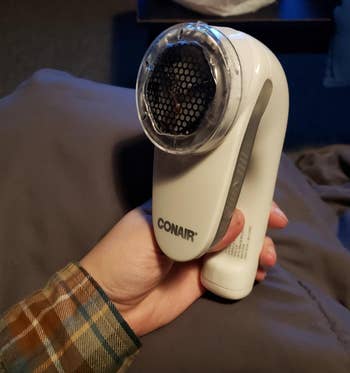 reviewer holding the white fabric shaver