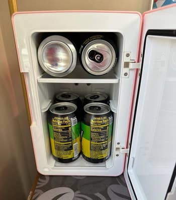 Mini fridge with six canned drinks inside