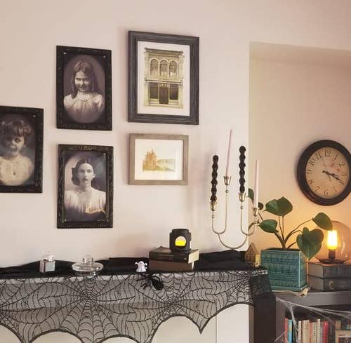 the three creepy victorian style portraits hung as a gallery wall above a reviewer's fireplace mantle