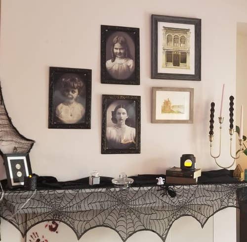 the three creepy victorian style portraits hung as a gallery wall above a reviewer's fireplace mantle