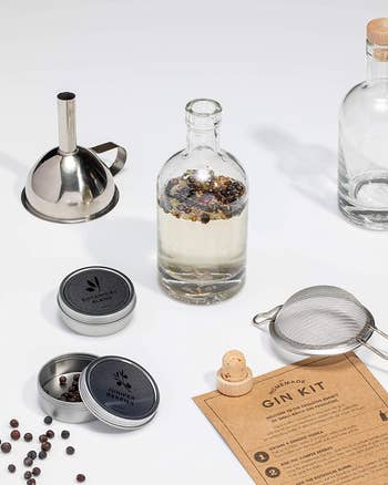 a bottle filled with homemade gin surrounded by other accessories from the kit