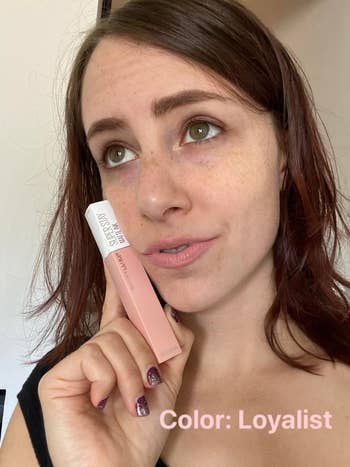 A idiosyncratic holding a Maybelline SuperStay Matte Ink lipstick, shadiness