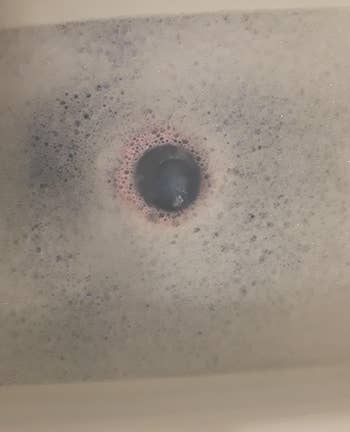 Bath bomb fizzing and turning the water blue in a reviewer's tub