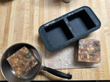 a reviewer's tray empty next to a cube of soup on the table and another cub in a pan