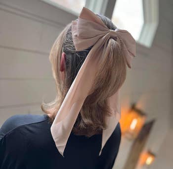 Person from behind wearing a large satin bow in their hair