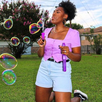 model wearing the PuffCuff, blowing bubbles