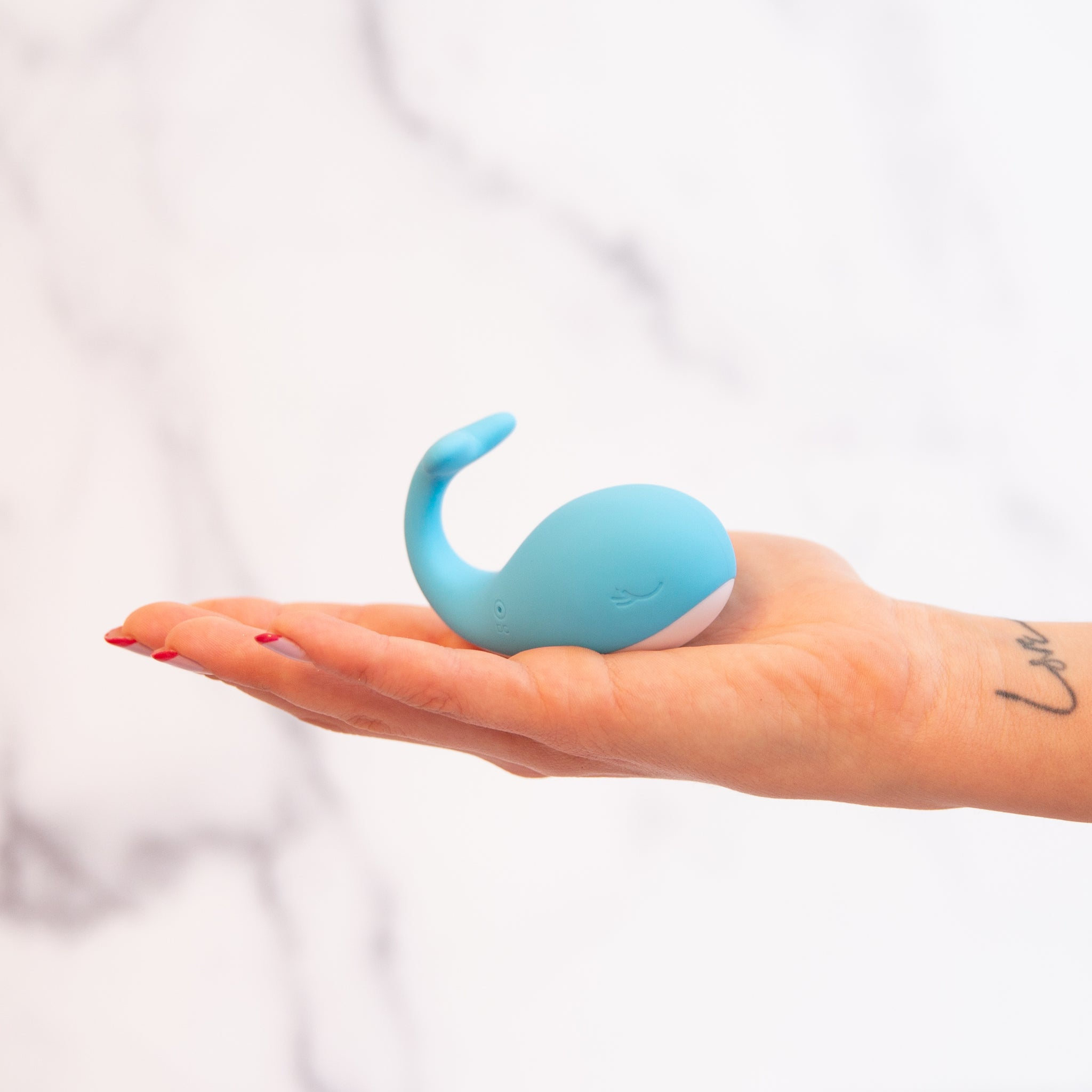 Model holding blue whale-shaped vibrator