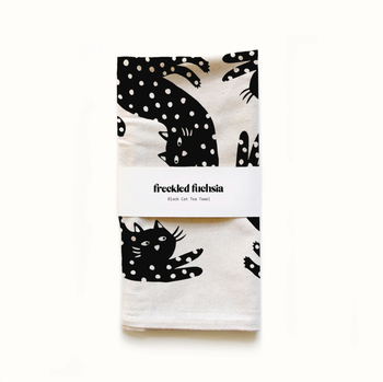 Black polka dotted cat on a white tea towel